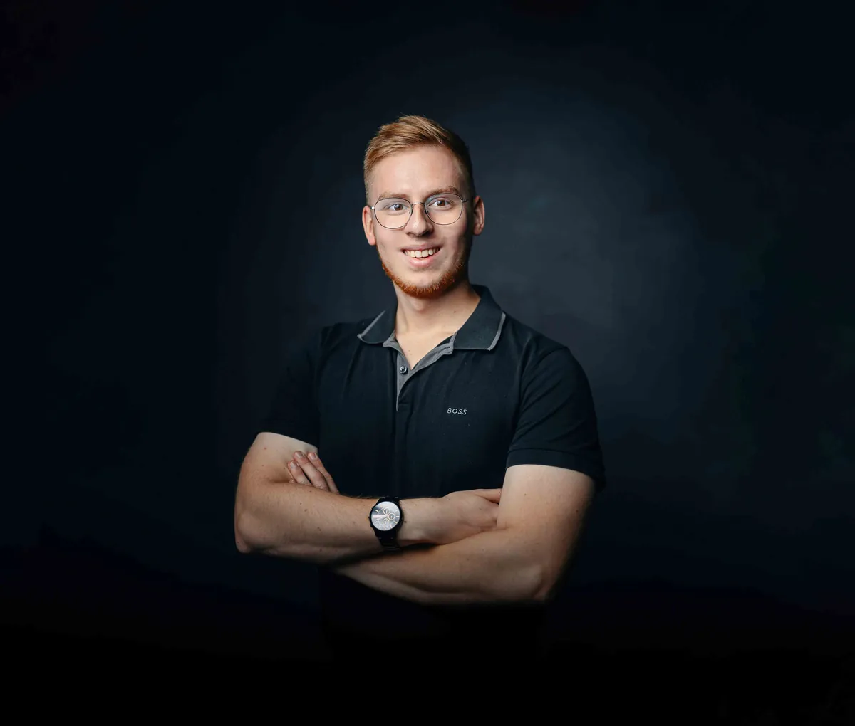 Fabian Bohr, Gründer von BOHR MEDIA, mit verschränkten Armen vor dunklem Hintergrund