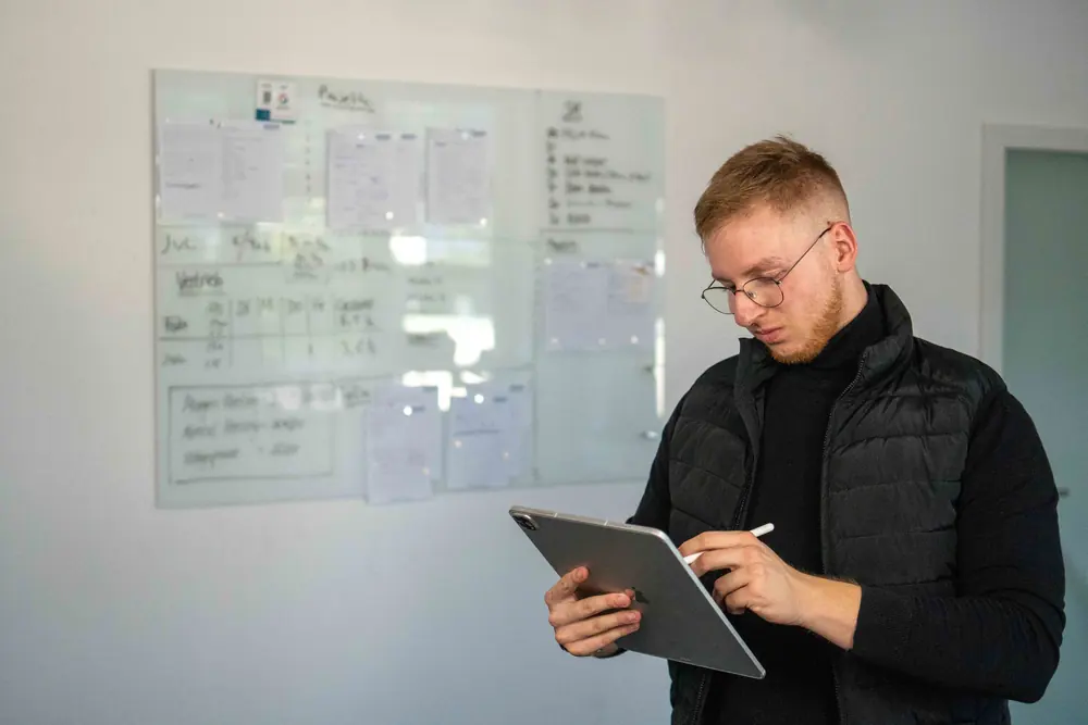 Fabian Bohr plant eine Strategie am Tablet im Büro von BOHR MEDIA