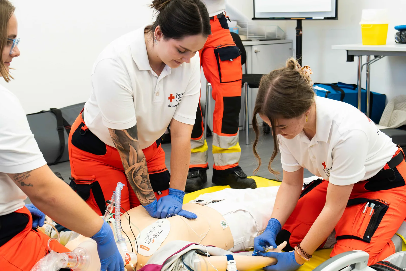 Rettungskräfte des DRK üben die Reanimation an einer Übungspuppe im Schulungsraum