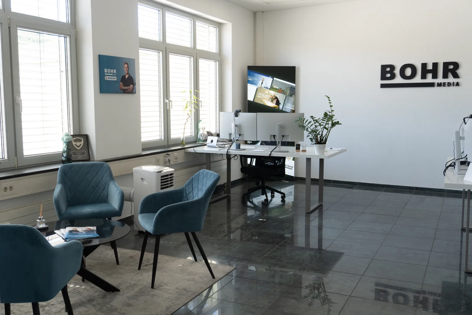Büro von BOHR MEDIA in Bernkastel-Kues mit Sitzecke, Arbeitsplätzen und Logo an der Wand