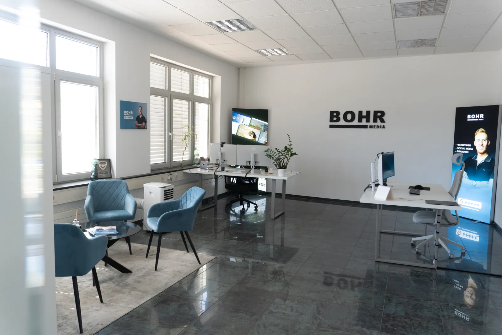Büro von BOHR MEDIA mit Arbeitsplätzen, Sitzecke und Logo-Wand